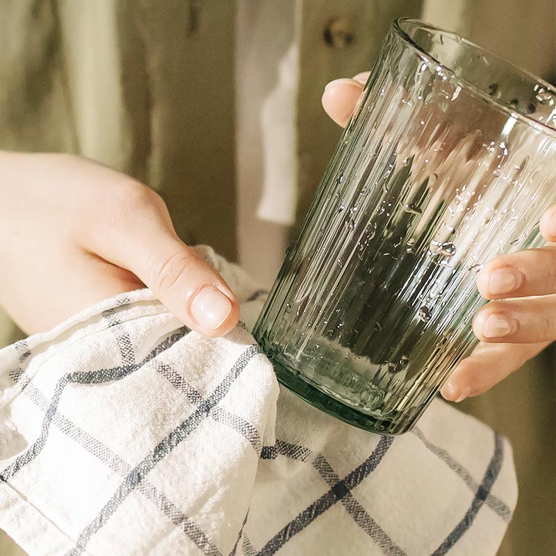 hand drying a clean cup after using natural dish soap