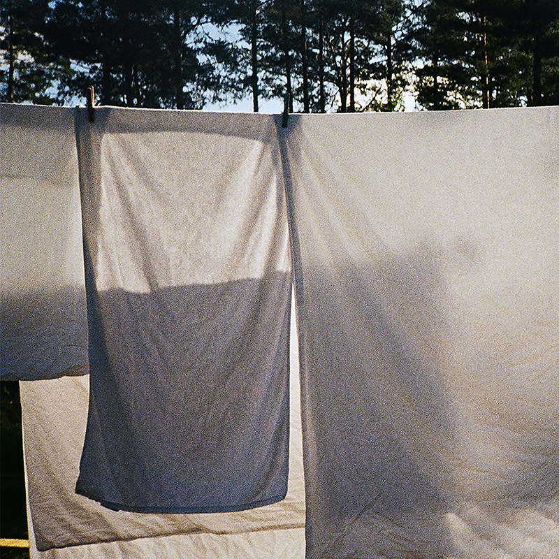 white sheets hanging on a line, blowing in the wind
